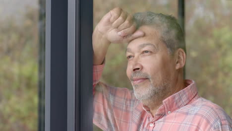 Happy-senior-biracial-man-looking-out-of-window-at-countryside,-copy-space,-slow-motion
