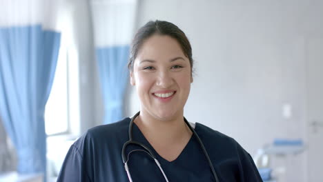 Portrait-of-happy-caucasian-female-doctor-smiling-in-hospital-ward,-slow-motion