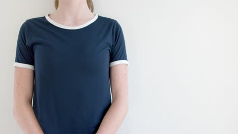 Midsection-of-caucasian-woman-in-navy-blue-t-shirt-with-white-edging,-copy-space,-slow-motion
