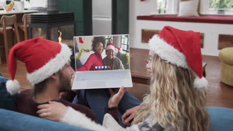 Happy-diverse-couple,-mother-and-daughter-having-christmas-laptop-video-call,-slow-motion