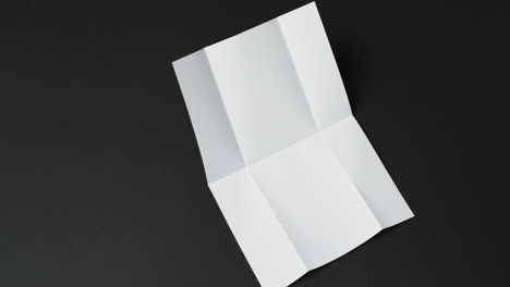 Video-Eines-Weißen-Blattes-Papier-Mit-Falten-Auf-Schwarzem-Hintergrund