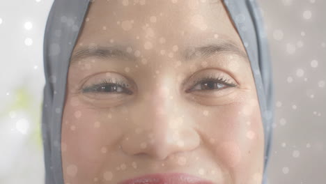 Animation-Von-Lichtpunkten-über-Einer-Lächelnden-Gemischtrassigen-Frau-Im-Hijab