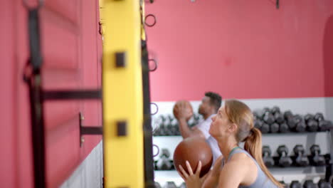 Fit-focused-gym-goers-engage-in-a-workout-session-with-medicine-balls