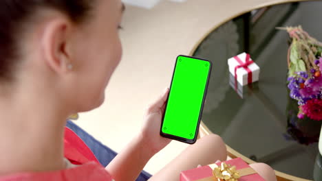 Caucasian-woman-holding-smartphone-with-copy-space-on-green-screen