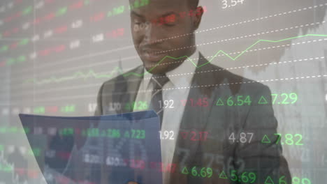 Animation-of-trading-board,-buildings,-african-american-man-standing-and-analyzing-reports