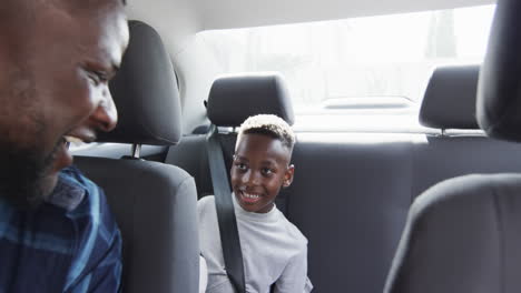 African-American-father-gives-high-five-to-son-in-car,-with-copy-space