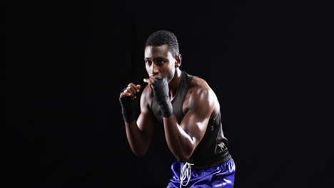 Boxeador-Afroamericano-Preparado-En-Una-Postura-De-Lucha-Sobre-Un-Fondo-Negro
