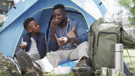 Afroamerikanischer-Vater-Und-Sohn-Genießen-Eine-Mahlzeit-In-Einem-Zelt