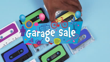 Animation-of-garage-sale-text-over-hand-holding-tape-on-blue-background