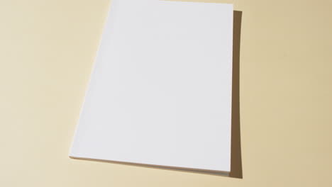 Video-of-book-with-blank-white-pages-and-copy-space-on-yellow-background