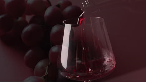 Composite-of-red-wine-being-poured-into-glass-over-grapes-on-red-background
