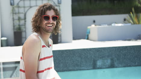 Young-Caucasian-man-enjoys-a-sunny-day-by-the-pool,-with-copy-space