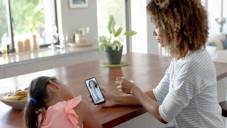 Madre-Birracial-E-Hija-Enferma-Teniendo-Videollamada-Con-Smartphone-Con-Doctora,-Cámara-Lenta