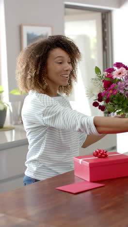Vertical-video-of-happy-biracial-woman-having-valentine's-day-smartphone-video-call,-slow-motion