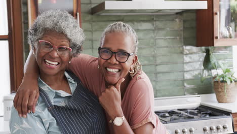 Portrait-of-happy-senior-african-american-female-friends-cooking-in-kitchen,-copy-space,-slow-motion