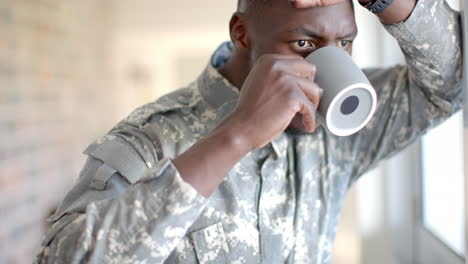 Un-Joven-Soldado-Afroamericano-Con-Uniforme-Militar-Disfruta-De-Un-Café-En-Casa