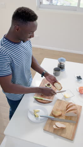 Afroamerikanischer-Mann-Bereitet-Toasts-In-Sonniger-Küche-Zu,-Zeitlupe
