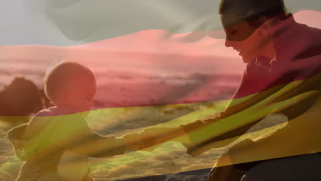 Animation-of-german-flag-over-caucasian-mother-and-child-playing-on-beach