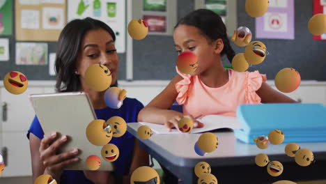 Animation-of-emoji-icons-over-biracial-schoolgirl-and-teacher-using-laptop
