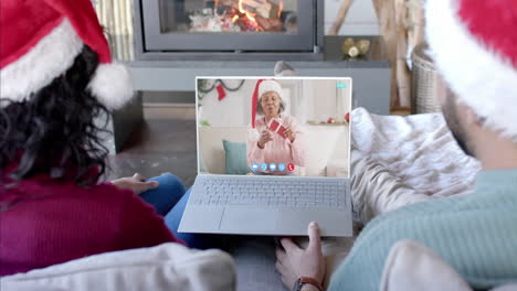 Happy-diverse-couple-and-senior-mother-having-christmas-laptop-video-call,-slow-motion