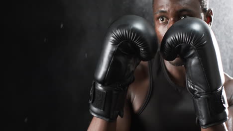 African-American-boxer-training-intensely-in-the-gym-on-a-black-background