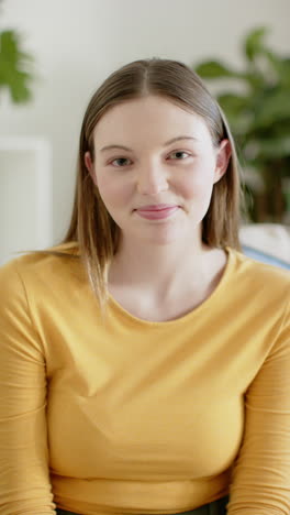 Vertical-video-of-portrait-of-happy-caucasian-woman-at-home,-in-slow-motion