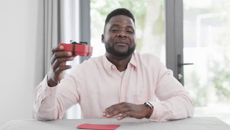 African-American-man-presents-a-gift-at-home-on-a-video-call