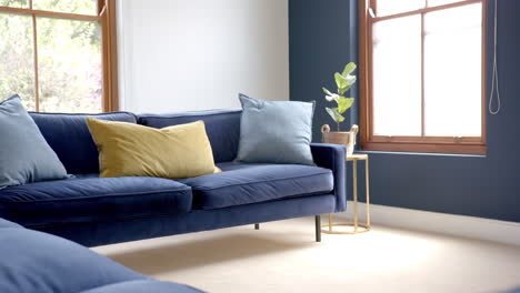 Kissen-Auf-Zwei-Blauen-Sofas-Im-Sonnigen-Wohnzimmer,-Kopierraum,-Zeitlupe