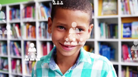 Animation-of-profile-icons-flowcharts-over-close-up-of-smiling-biracial-boy-standing-in-library