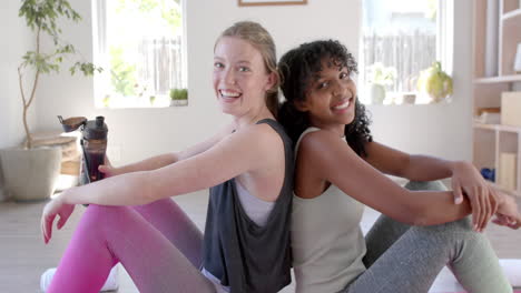Portrait-of-happy-diverse-women-teenage-girl-exercising-in-aerial-yoga-class,-slow-motion