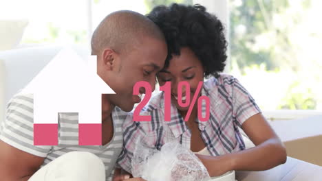 Animation-of-house-icon-and-percent-in-pink-over-diverse-couple-moving-in-unpacking-boxes