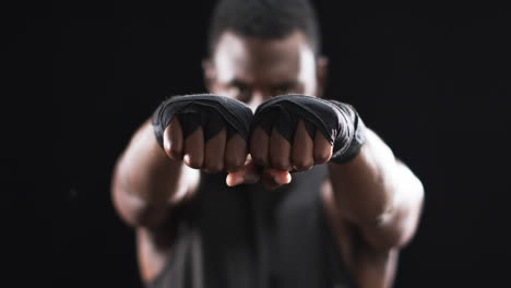 African-American-boxer-shows-off-boxing-gloves-on-a-black-background