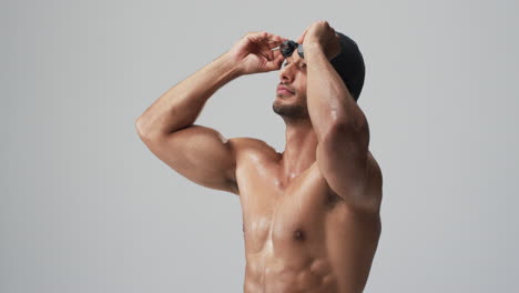 Athletic-young-biracial-athlete-swimmer-adjusts-his-swimming-goggles