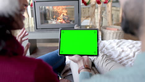 Happy-diverse-couple-having-christmas-tablet-video-call-with-green-screen,-slow-motion