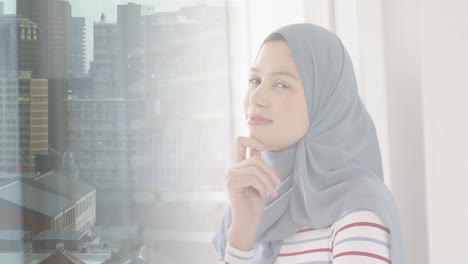 Animation-Einer-Stadtlandschaft-über-Einer-Lächelnden-Gemischtrassigen-Frau-Im-Hijab