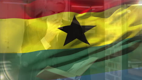 Animation-of-flag-of-ghana-over-caucasian-businessman-studying-book-in-library