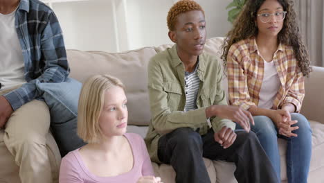 Thoughtful-diverse-group-of-teenage-friends-at-meeting-talking-at-home,-slow-motion