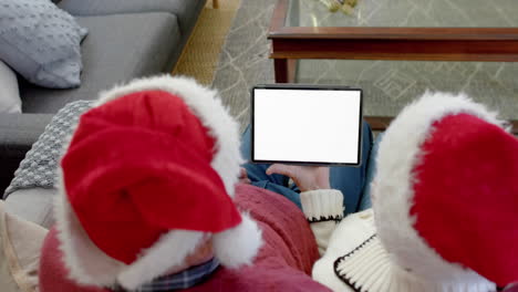 Happy-caucasian-couple-having-christmas-tablet-video-call-with-copy-space-screen,-slow-motion