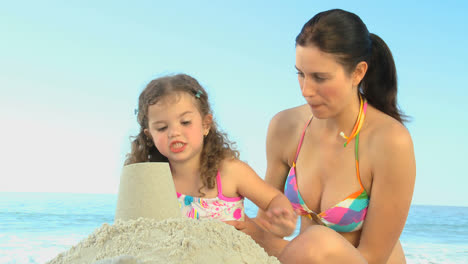 Beautiful-mother-playing-with-her-daughter-on-the-sand