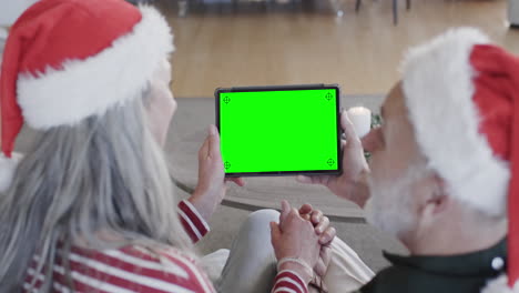 Caucasian-senior-couple-having-christmas-tablet-video-call-with-green-screen,-slow-motion