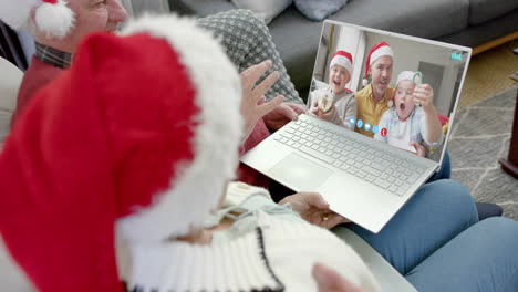 Glückliches-Kaukasisches-Paar-Und-Vater-Mit-Söhnen,-Die-Einen-Weihnachtlichen-Laptop-Videoanruf-In-Zeitlupe-Führen