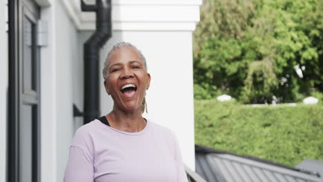 Portrait-of-happy-senior-african-american-woman-laughing-in-garden,-copy-space,-slow-motion