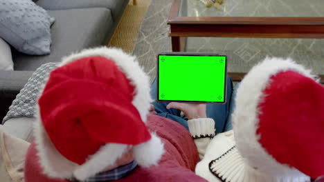 Senior-caucasian-couple-having-christmas-tablet-video-call-with-green-screen,-slow-motion