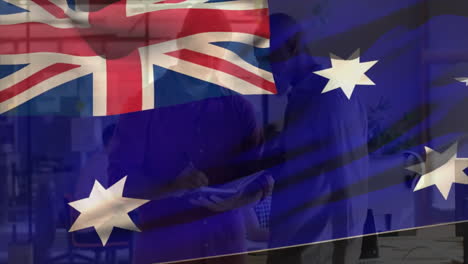 Animation-of-flag-of-australia-over-two-diverse-male-business-colleagues-discussing-in-casual-office