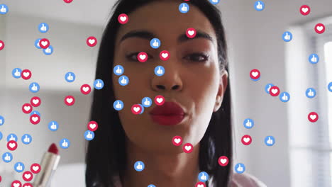 Animation-of-social-media-icons-over-biracial-woman-applying-lipstick