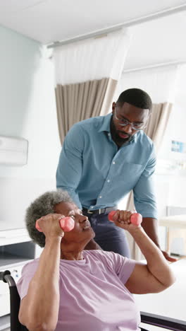 Vertical-video-of-senior-african-american-woman-and-male-doctor-in-hospital,-slow-motion,-copy-space