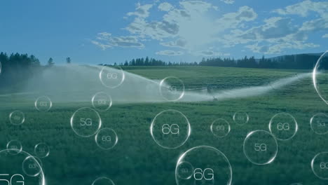 Animation-of-circles-with-5g-and-6g-texts-over-landscape-with-water-sprinkler-on-field