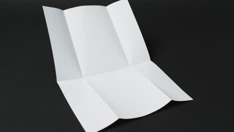 Video-of-piece-of-white-paper-with-creases-on-black-background