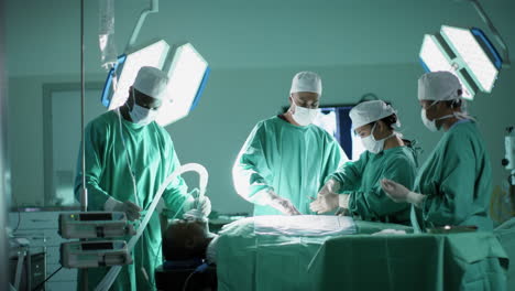 Diversos-Cirujanos-Masculinos-Y-Femeninos-Operando-A-Un-Paciente-En-El-Quirófano-Del-Hospital,-En-Cámara-Lenta