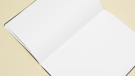 Video-of-book-with-white-blank-pages-and-copy-space-on-yellow-background